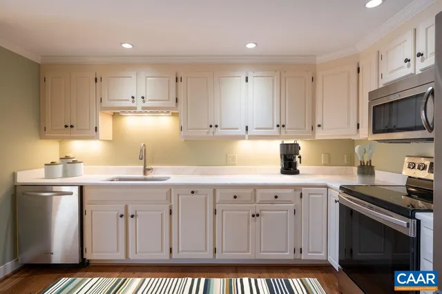 a kitchen with granite countertop a sink stove and cabinets