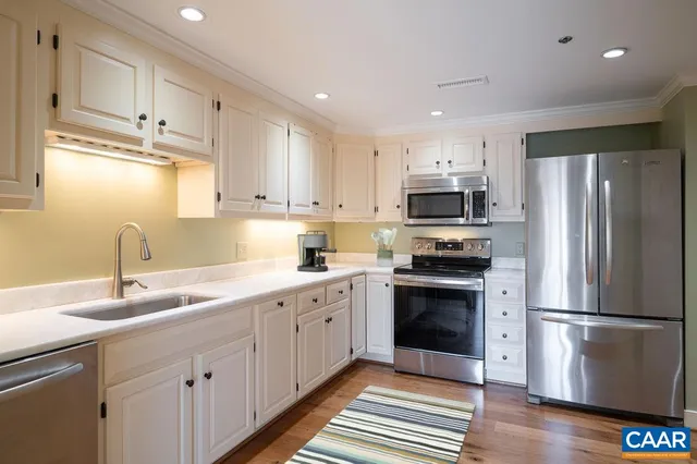 a kitchen with stainless steel appliances granite countertop a refrigerator sink and stove