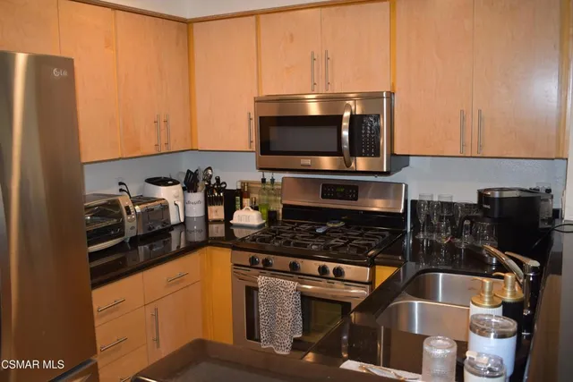 a kitchen with a sink a stove and a microwave