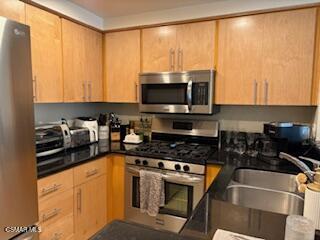 4240 Lost Hills Road, Unit 2901 Calabasas, CA 91301 - Photo 5 of 15 a kitchen with a sink a stove and a microwave