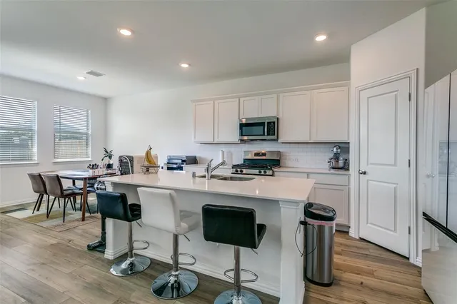 a kitchen with stainless steel appliances a sink stove and refrigerator