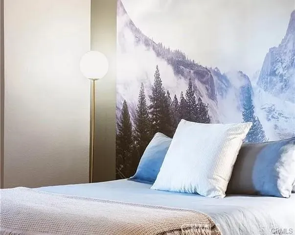 a bedroom with a bed and a lamp with the potted plant