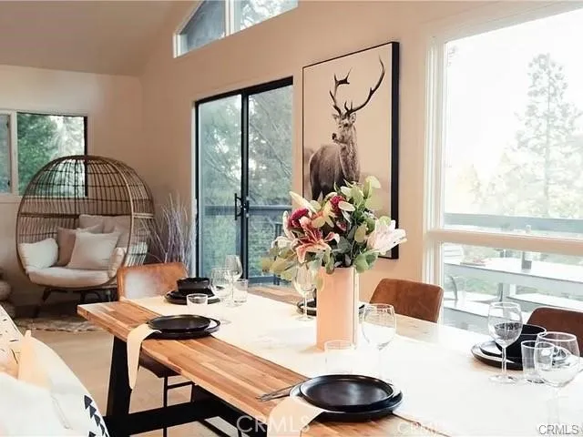 a dining room with furniture and a large window