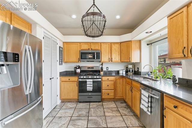 8291 Tibbs Road Peyton, CO 80831 - Photo 12 of 25 Kitchen featuring an inviting chandelier, a sink, appliances with stainless steel finishes, and recessed lighting
