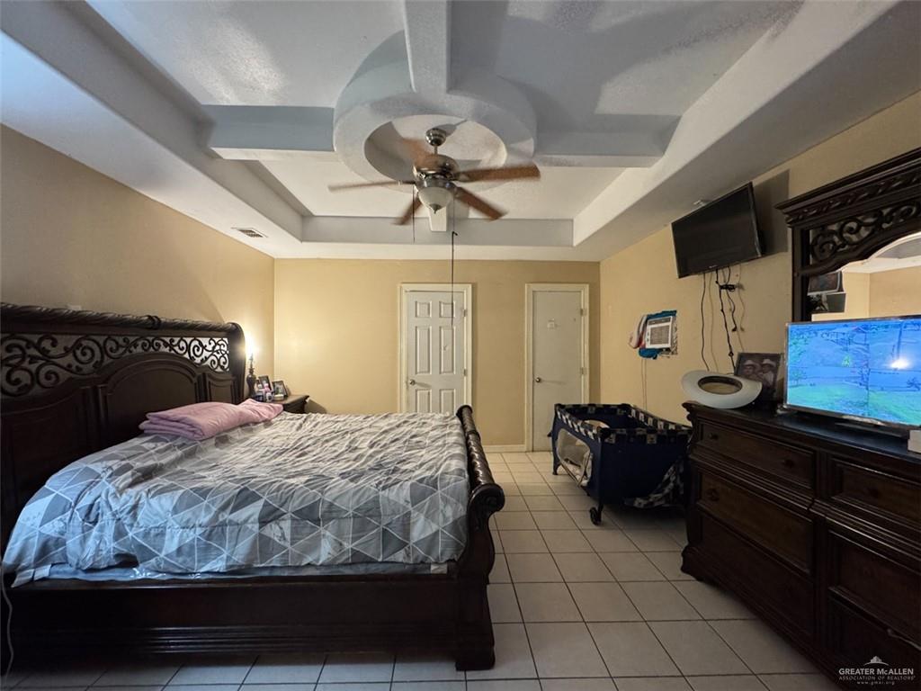 23960 North Texan Road Edinburg, TX 78541 - Photo 7 of 31 a bedroom with a bed and a chandelier