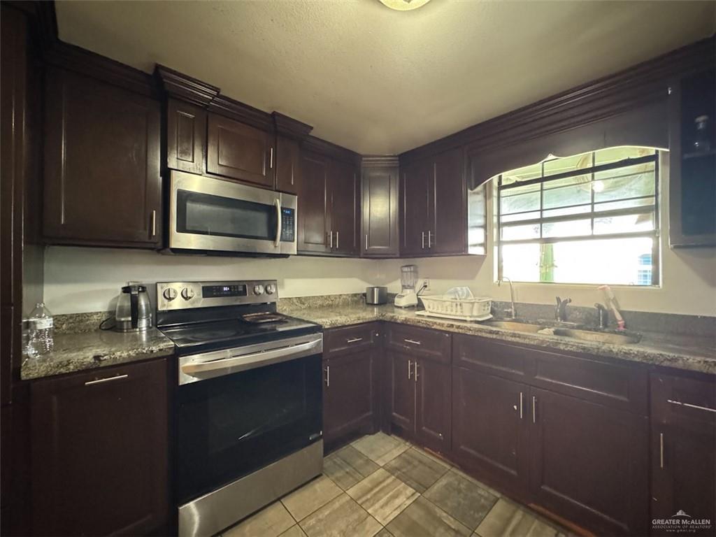 23960 North Texan Road Edinburg, TX 78541 - Photo 9 of 31 a kitchen with a sink stove top oven and microwave