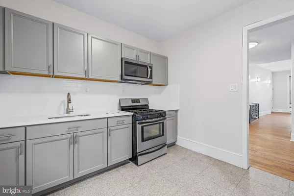 a kitchen with white cabinets stainless steel appliances and sink