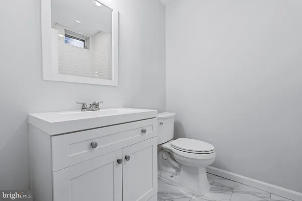 a bathroom with a sink mirror and toilet