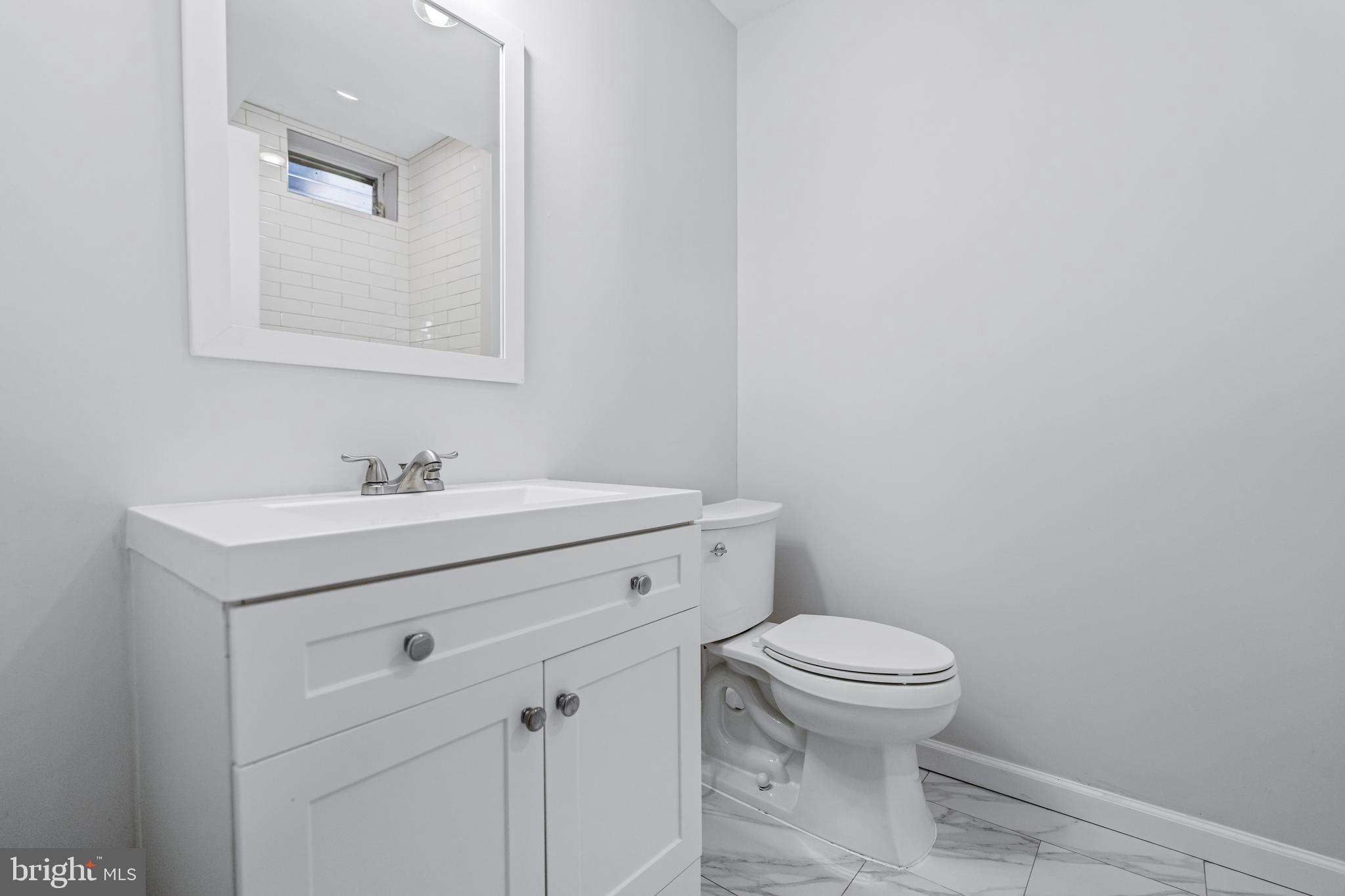 2303 Christian Street, Unit 1 Philadelphia, PA 19146 - Photo 10 of 21 a bathroom with a sink mirror and toilet