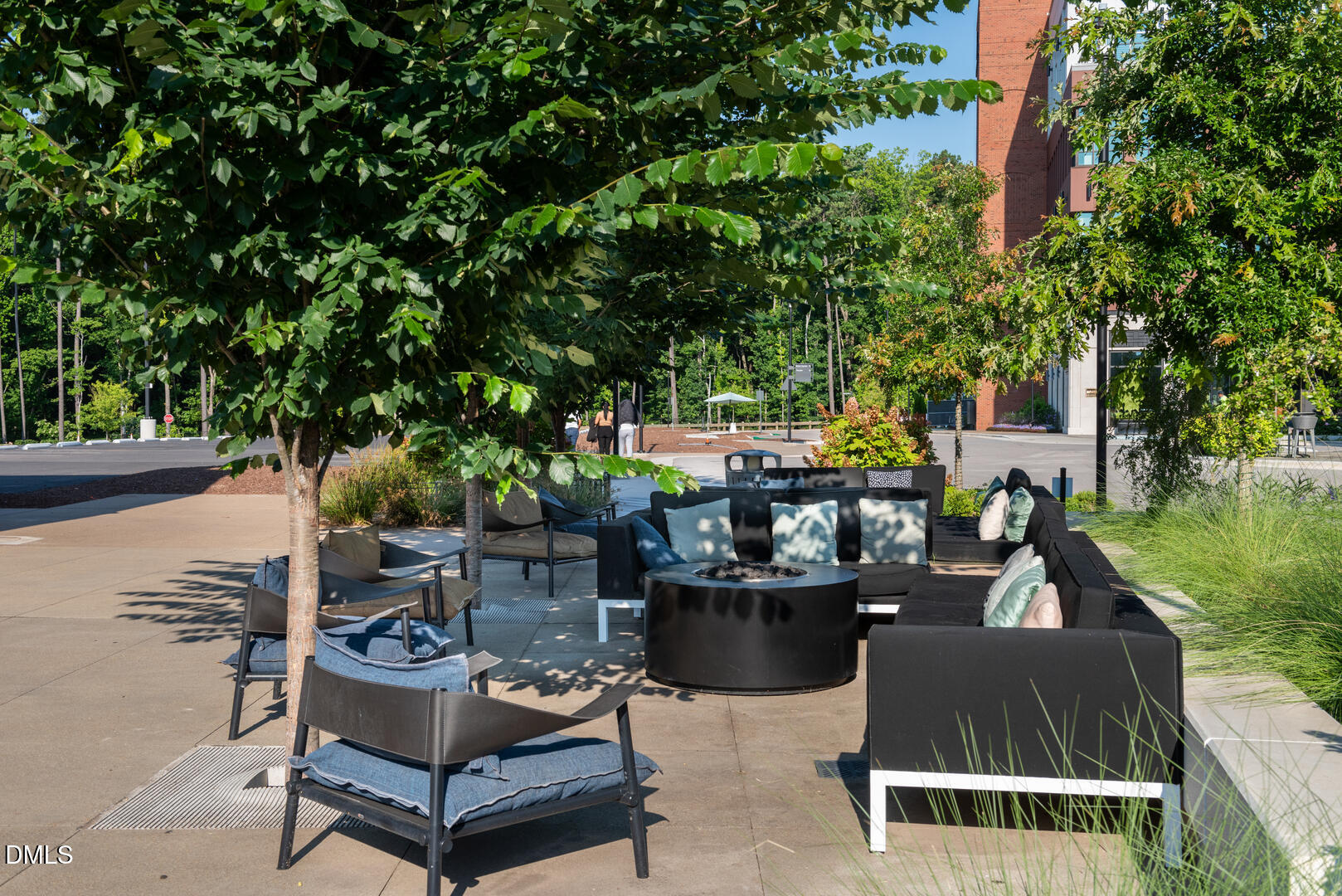 620 Hedrick Ridge Road, Unit 112 Cary, NC 27519 - Photo 25 of 34 a view of a patio with couches and a table and chairs with plants and trees
