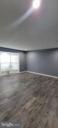 a view of wooden floor and window in an empty room