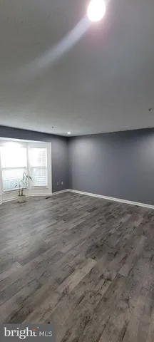 a view of wooden floor and window in an empty room