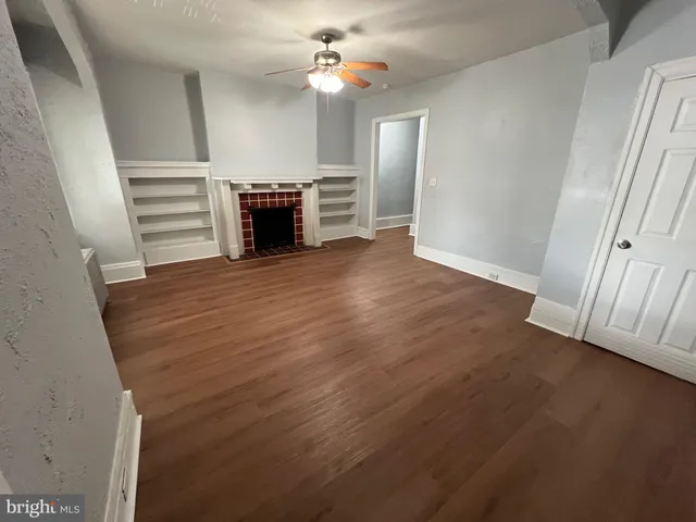 wooden floor in an empty room with a fireplace