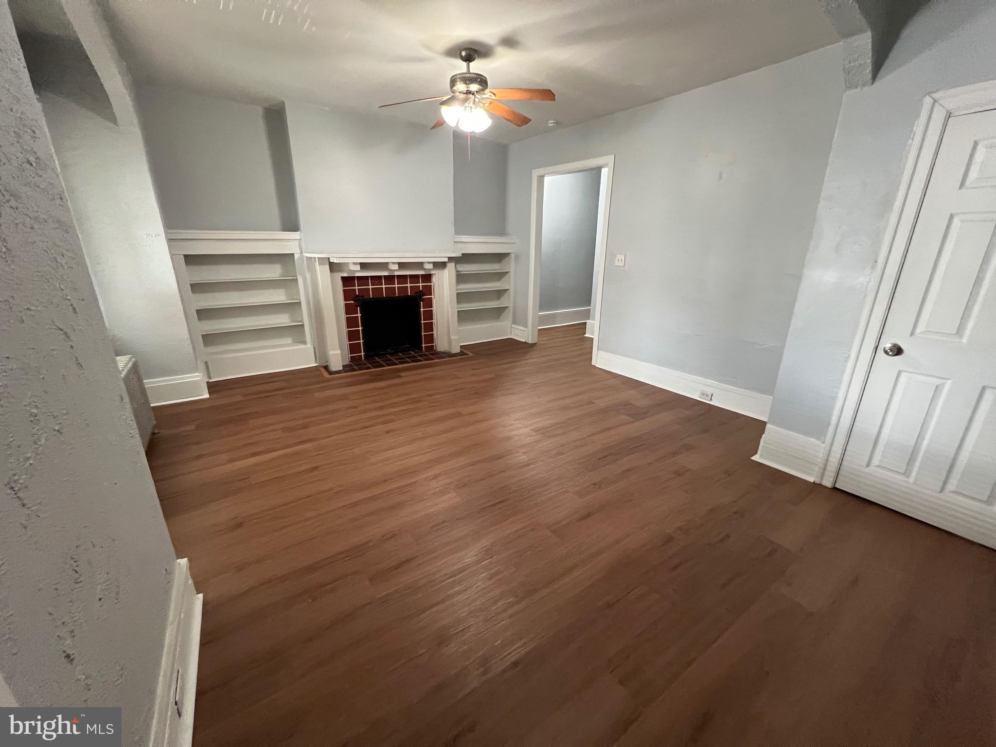 5533 Walnut Street, Unit 2 Philadelphia, PA 19139 - Photo 1 of 23 wooden floor in an empty room with a fireplace