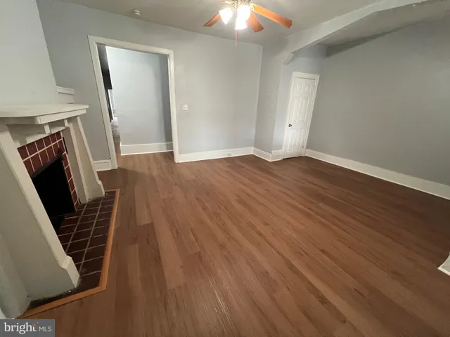 an empty room with wooden floor and staircase