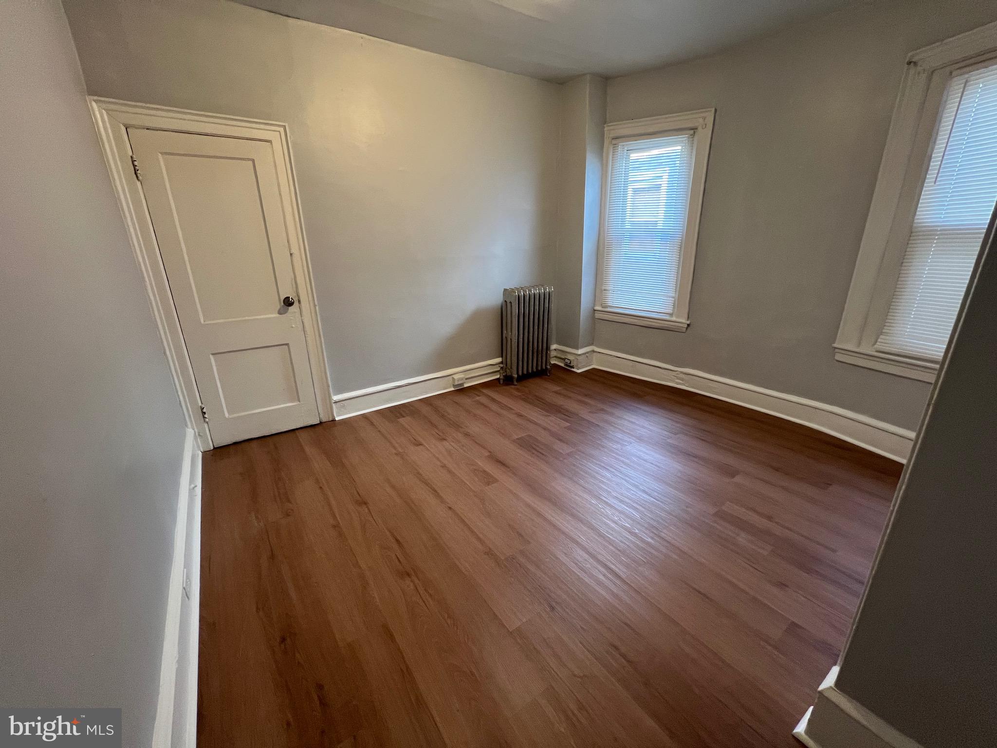 5533 Walnut Street, Unit 2 Philadelphia, PA 19139 - Photo 9 of 23 an empty room with wooden floor and mirror