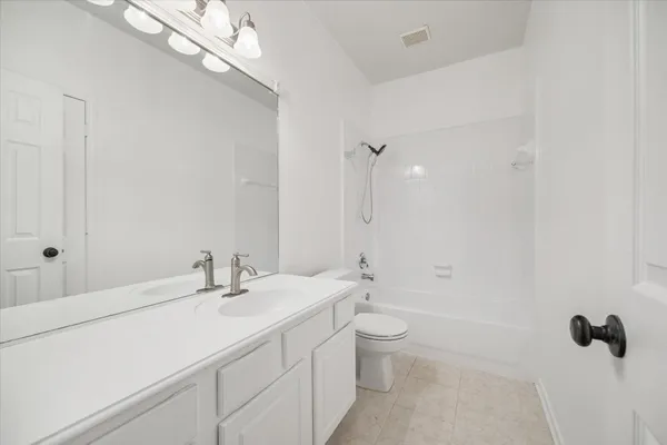 a bathroom with a double vanity sink a toilet and a mirror