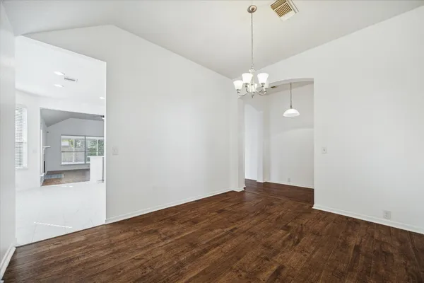 a view of a chandelier in big room with wooden floor