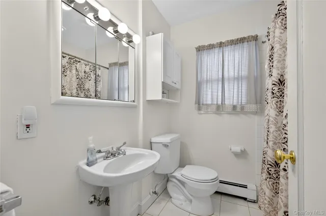 a bathroom with a sink toilet and a mirror