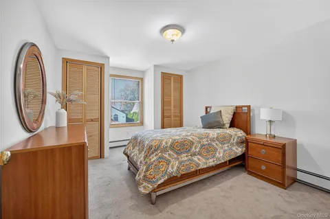 a bedroom with a bed and a dresser next to a window