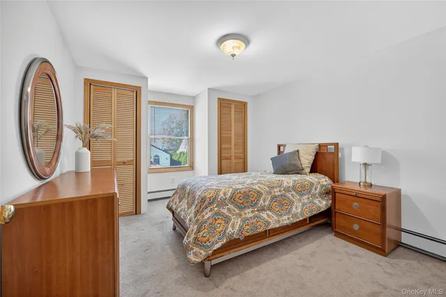 a bedroom with a bed and a dresser next to a window