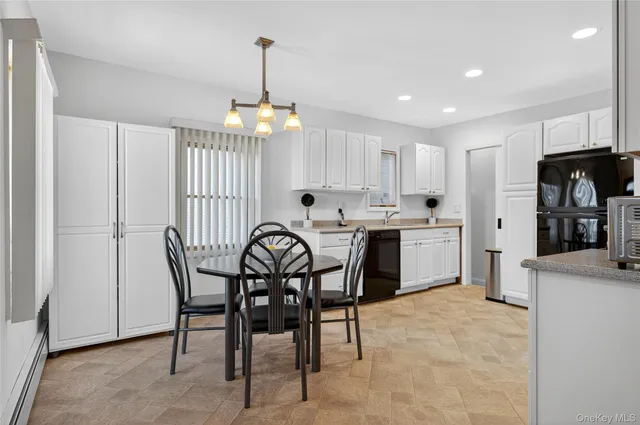 a view of a dining room and livingroom with furniture wooden floor a chandelier