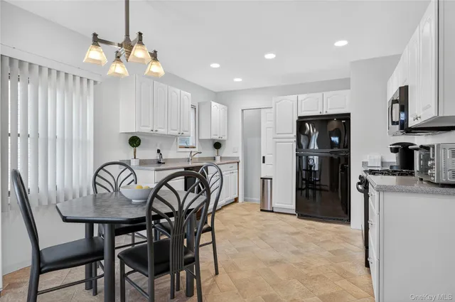a kitchen with stainless steel appliances kitchen island granite countertop a dining table chairs refrigerator and sink
