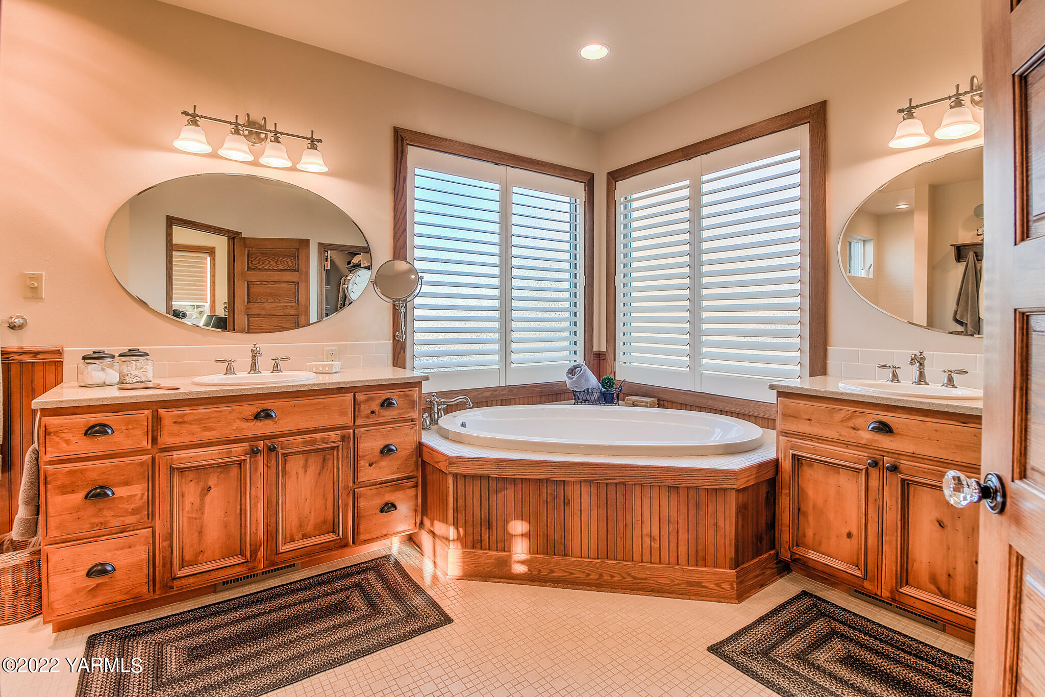 11392 Zier Road Yakima, WA 98908 - Photo 17 of 47 a bathroom with a sink a mirror and a bathtub next to a window