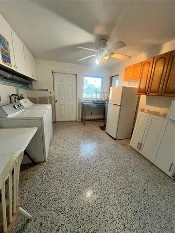 a kitchen with white cabinets and appliances