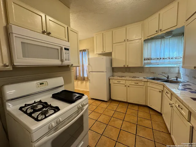 a kitchen with a stove a sink and a refrigerator