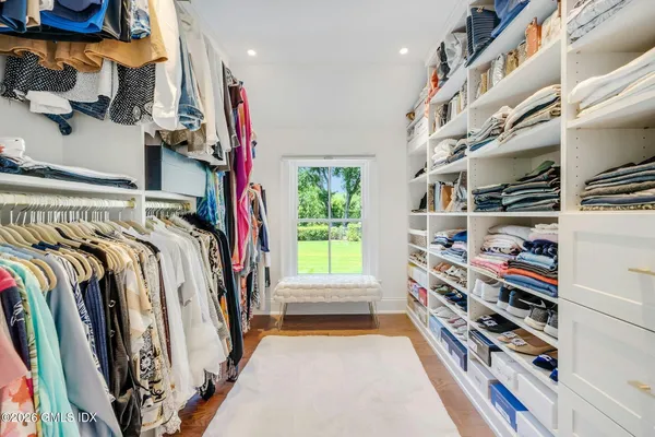 a view of walk in closet with clothes and shoes