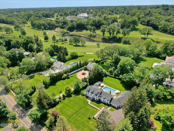 an aerial view of a houses with a lush green hillside