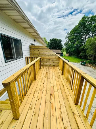 a view of balcony with wooden floor and fence