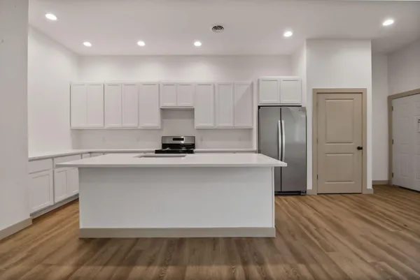 a kitchen with kitchen island a sink appliances and cabinets