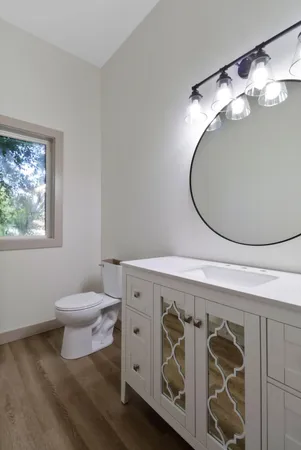 a bathroom with a toilet a sink and mirror