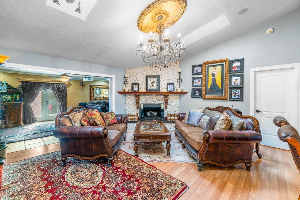 294 Northwest 69th Street Boca Raton, FL 33487 - Photo 11 of 39 a living room with furniture a chandelier and a fireplace
