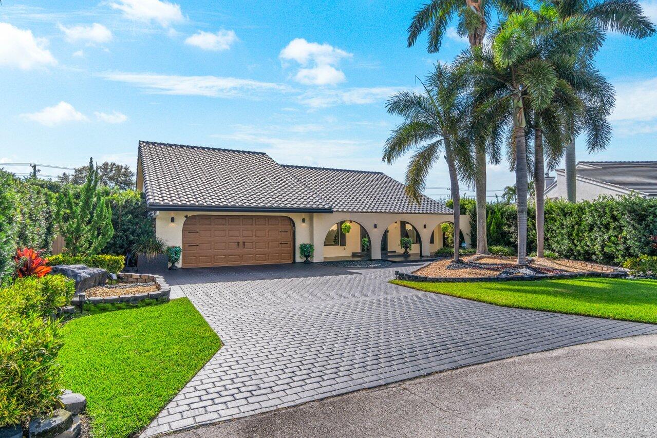 294 Northwest 69th Street Boca Raton, FL 33487 - Photo 2 of 39 a front view of a house with garden