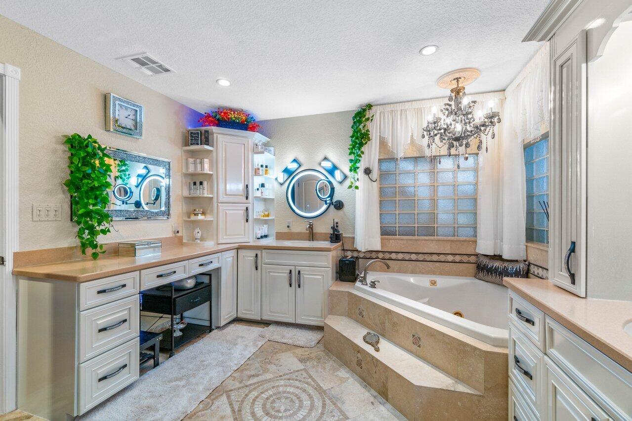 294 Northwest 69th Street Boca Raton, FL 33487 - Photo 21 of 39 a spacious bathroom with a granite countertop tub sink and mirror