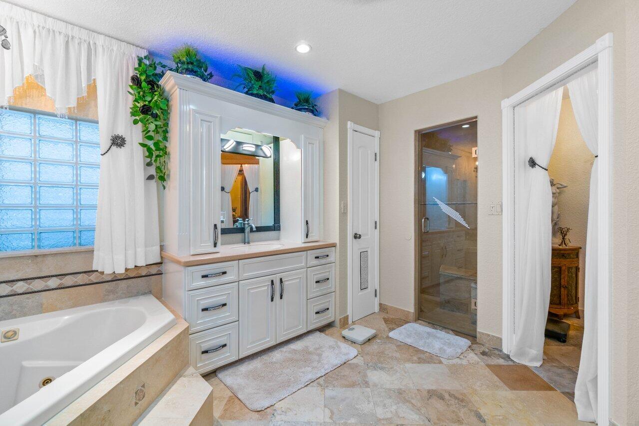 294 Northwest 69th Street Boca Raton, FL 33487 - Photo 22 of 39 a bathroom with a tub sink and mirror