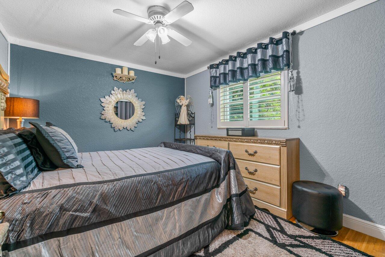 294 Northwest 69th Street Boca Raton, FL 33487 - Photo 27 of 39 a bedroom with a bed and a chandelier