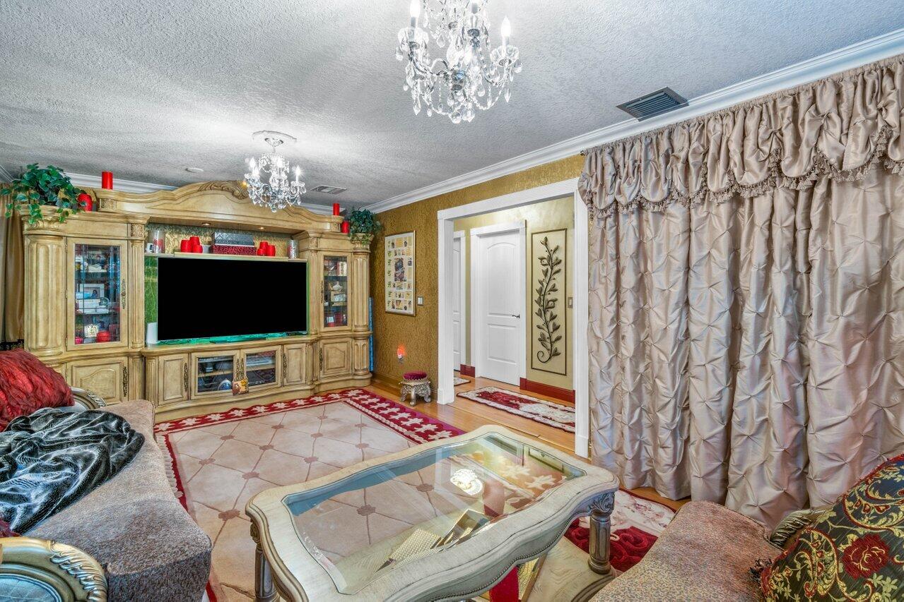 294 Northwest 69th Street Boca Raton, FL 33487 - Photo 29 of 39 a living room with furniture and a flat screen tv
