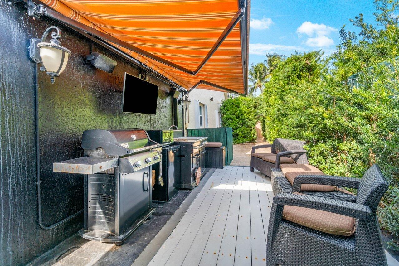 294 Northwest 69th Street Boca Raton, FL 33487 - Photo 30 of 39 a view of a patio with table and chairs with wooden floor and fence
