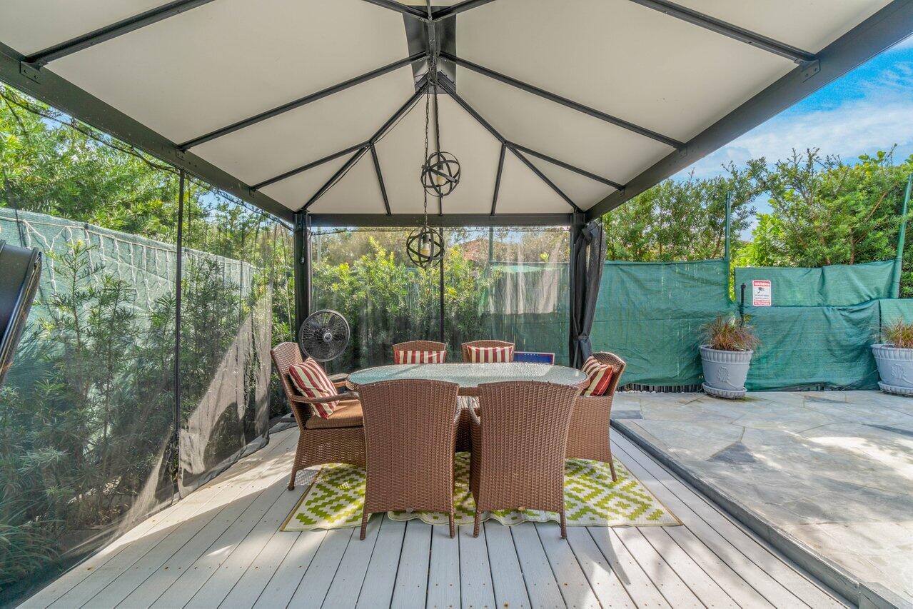 294 Northwest 69th Street Boca Raton, FL 33487 - Photo 34 of 39 a view of a patio with table and chairs under an umbrella