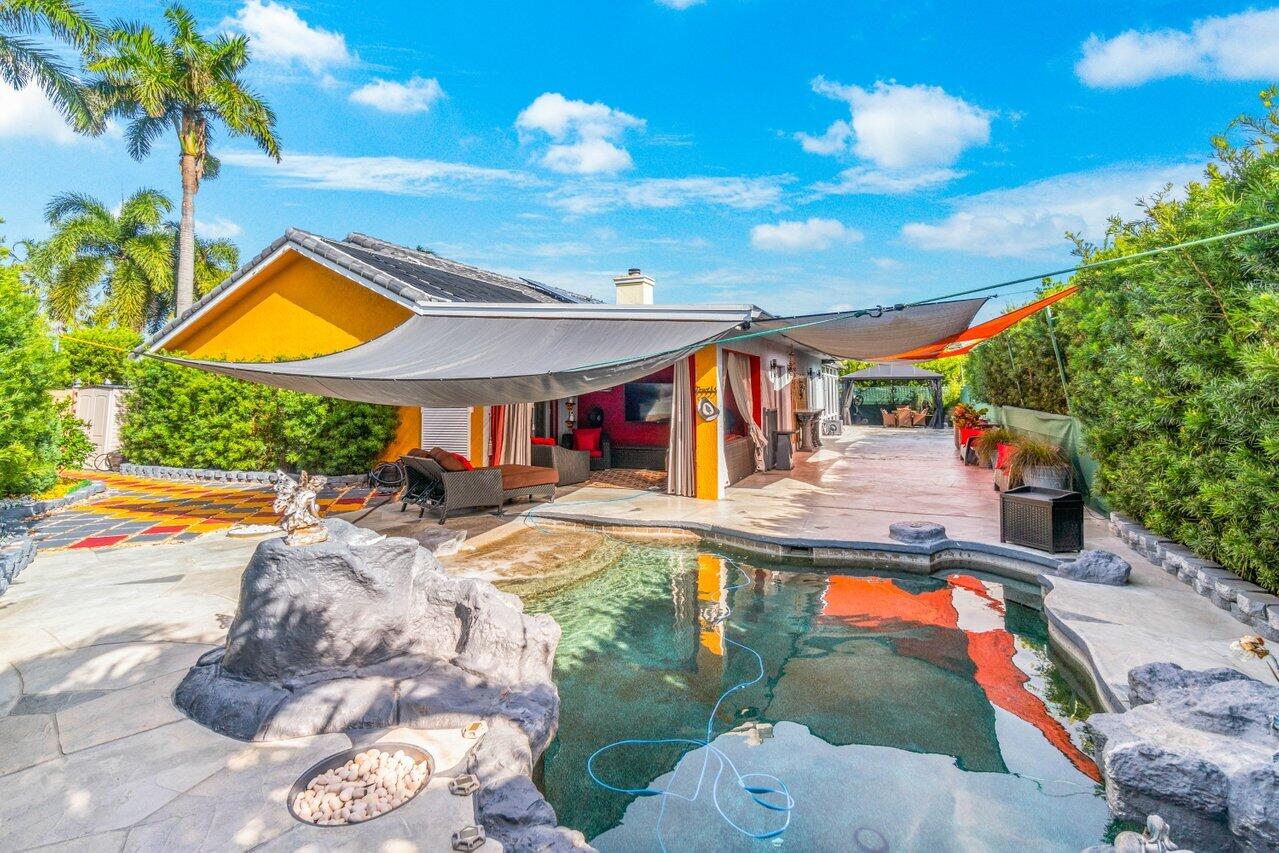 294 Northwest 69th Street Boca Raton, FL 33487 - Photo 36 of 39 a view of swimming pool with a table and chairs under an umbrella