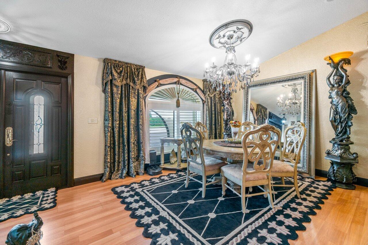 294 Northwest 69th Street Boca Raton, FL 33487 - Photo 5 of 39 a view of a dining room with furniture and chandelier