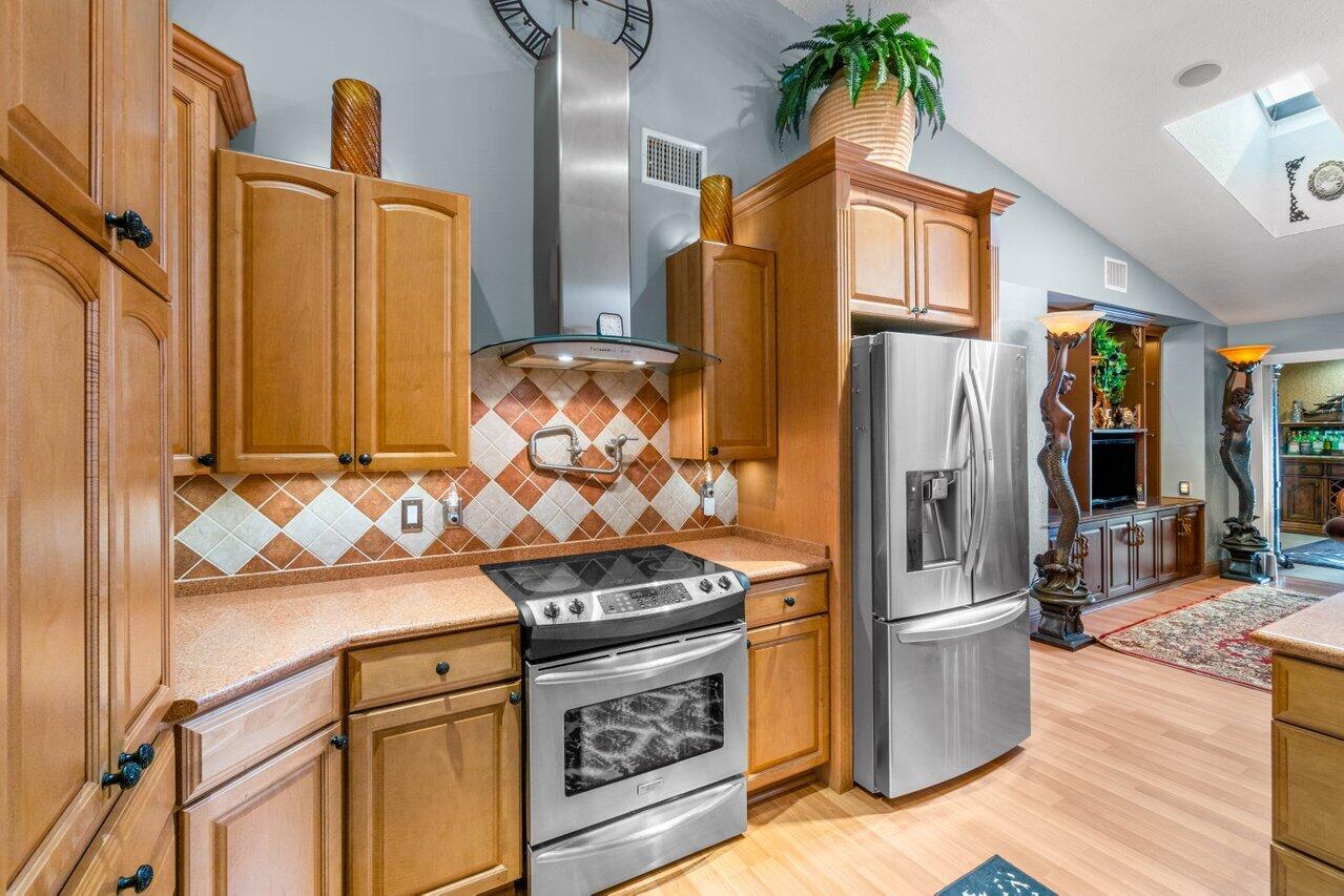 294 Northwest 69th Street Boca Raton, FL 33487 - Photo 10 of 39 a kitchen with stainless steel appliances granite countertop a refrigerator and a stove