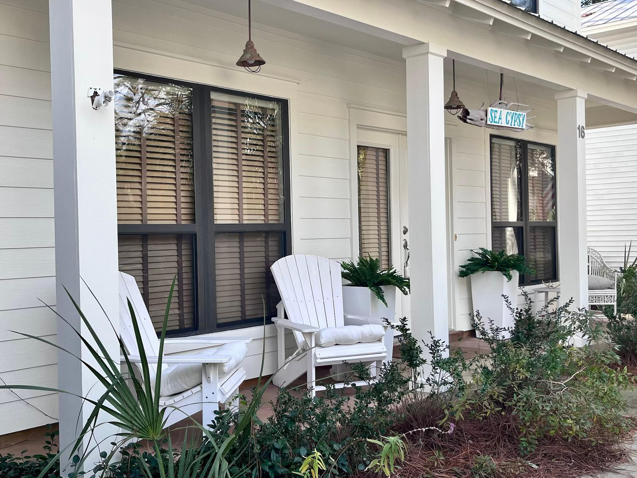 a view of a porch with chairs and potted plants