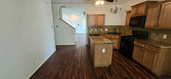 a kitchen with stainless steel appliances granite countertop a sink stove and wooden floor