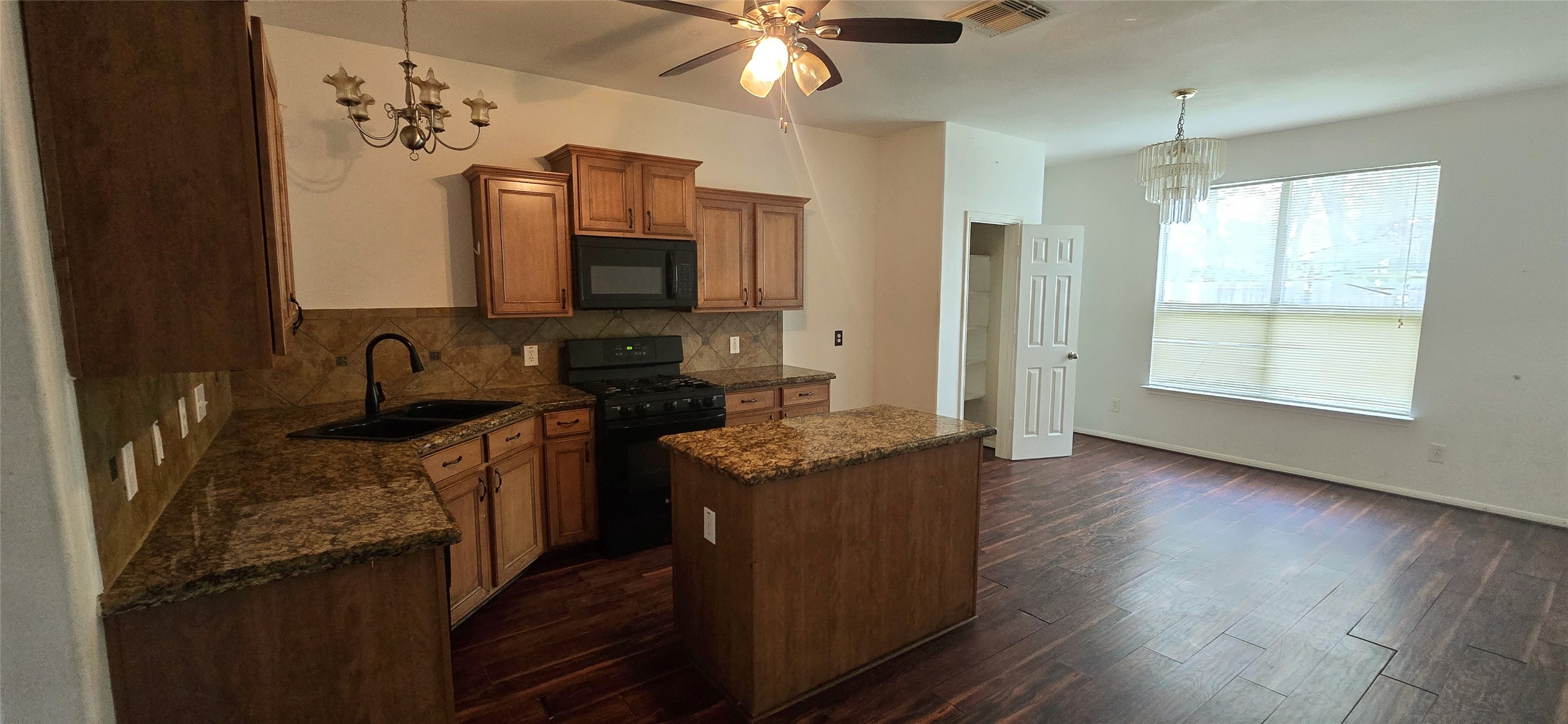 23526 Whispering Maple Drive Spring, TX 77373 - Photo 9 of 23 a kitchen with stainless steel appliances granite countertop a sink stove and wooden floor