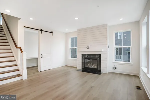 a kitchen with stainless steel appliances granite countertop a sink a stove a refrigerator and white cabinets